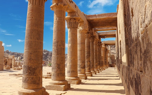 Pillars and passage inside Philae Temple, Aswan, Egypt, showcasing ancient Egyptian architecture.