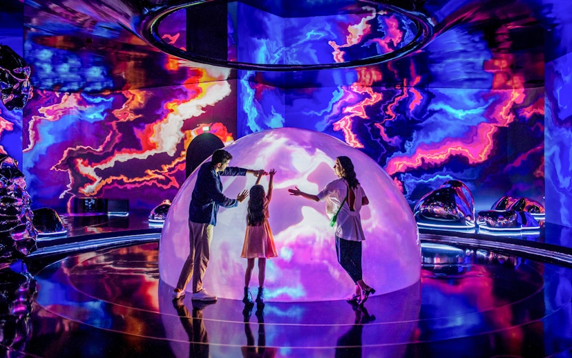 Family exploring interactive light display at The Source, AYA Universe, Dubai.