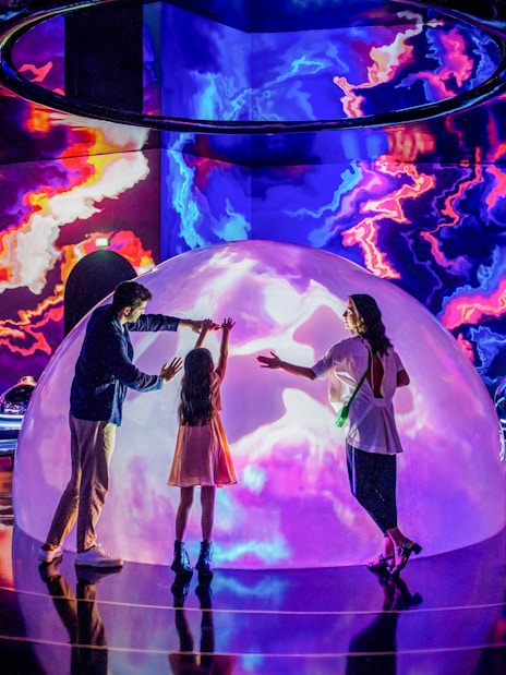 Family exploring interactive light display at The Source, AYA Universe, Dubai.