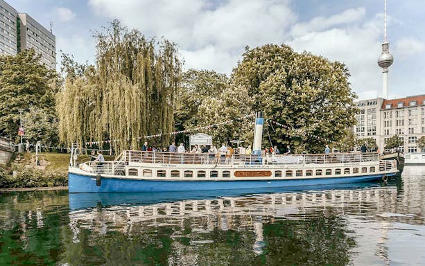 Tour boat on Berlin's Spree River with TV Tower in background during 3-hour bridge cruise.