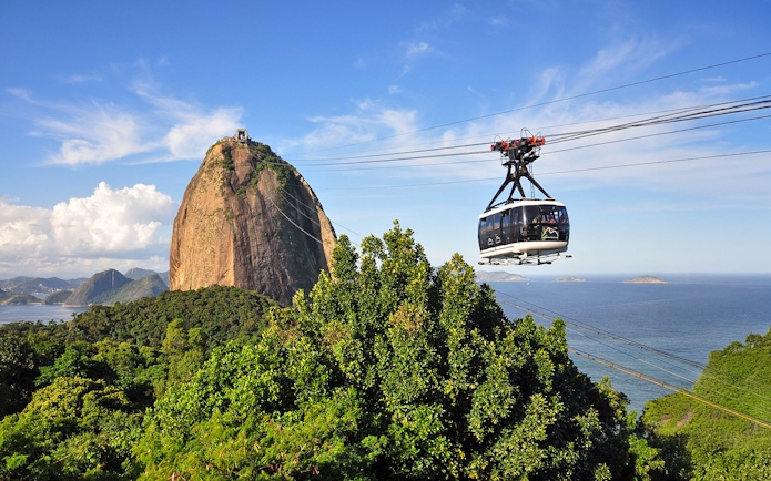Cable car ascending to Sugarloaf Mountain, Rio de Janeiro, with ocean view.