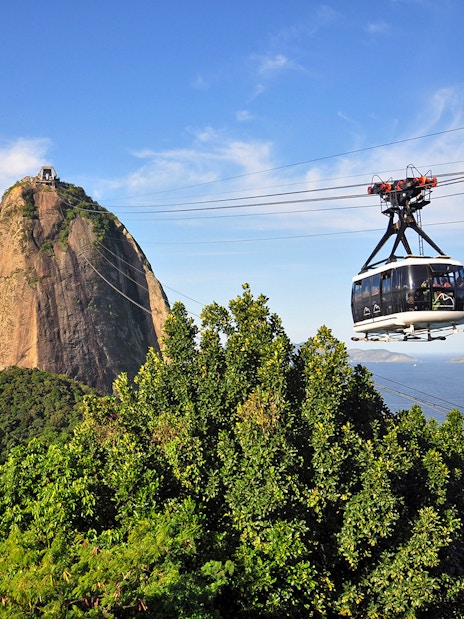 Cable car ascending to Sugarloaf Mountain, Rio de Janeiro, with ocean view.
