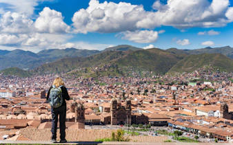 Tourist admiring Cusco cityscape from Mirador de San Cristobal, Peru.