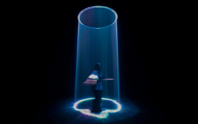 Visitor interacting with light sculpture at Singapore's ArtScience Museum.