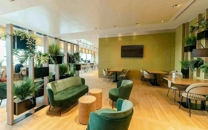 Brussels Airport Lounge interior with green seating and plants.