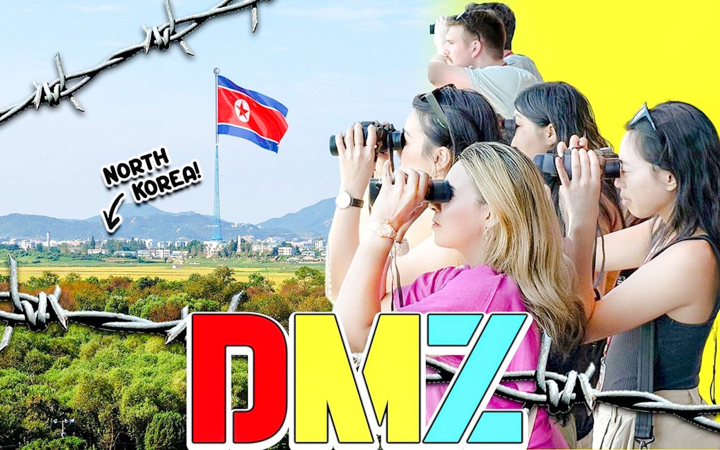 Tour group at DMZ observatory using binoculars to view North Korean village and flag.