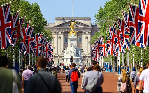 Tourists walking towards Buckingham Palace on Westminster tour, London.