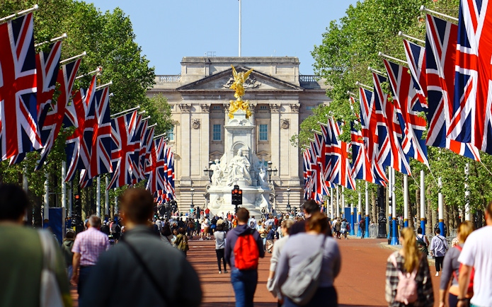 Tourists walking towards Buckingham Palace on Westminster tour, London.
