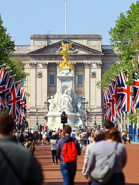 Tourists walking towards Buckingham Palace on Westminster tour, London.
