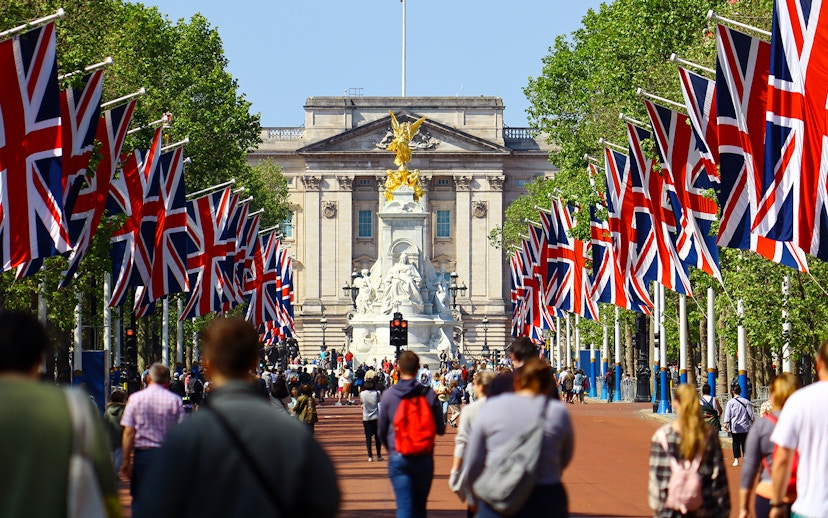 Tourists walking towards Buckingham Palace on Westminster tour, London.