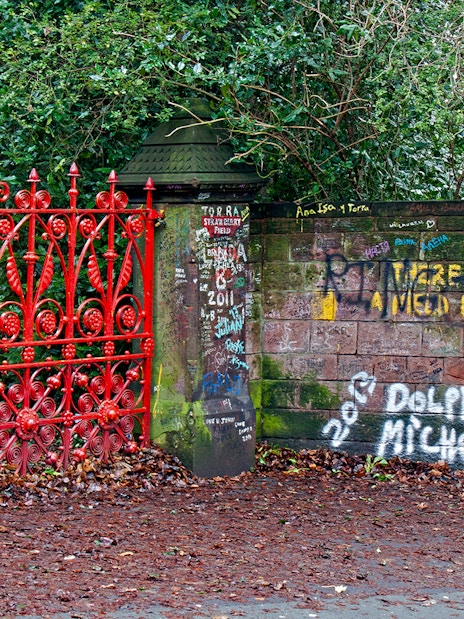 Strawberry Field Gates in Liverpool with graffiti-covered brick wall.