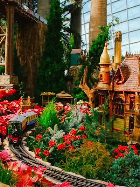 Christmas train display at Gardens by the Bay with festive decorations and model house.
