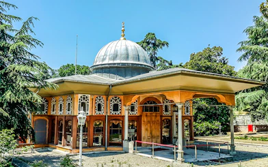Aynalıkavak Pavilion with ornate windows and dome, surrounded by trees in Istanbul.