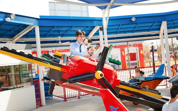Family enjoying a colorful airplane ride at Legoland Korea.