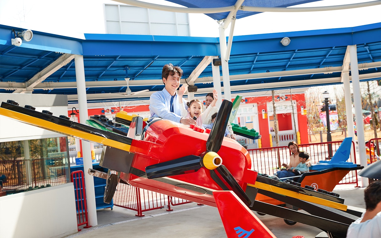 Family enjoying a colorful airplane ride at Legoland Korea.