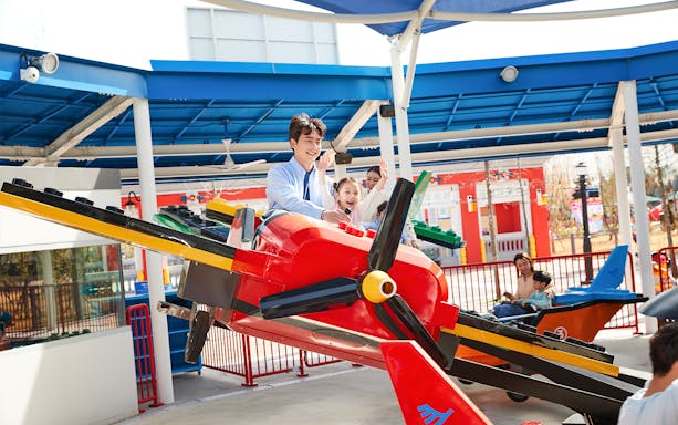 Family enjoying a colorful airplane ride at Legoland Korea.