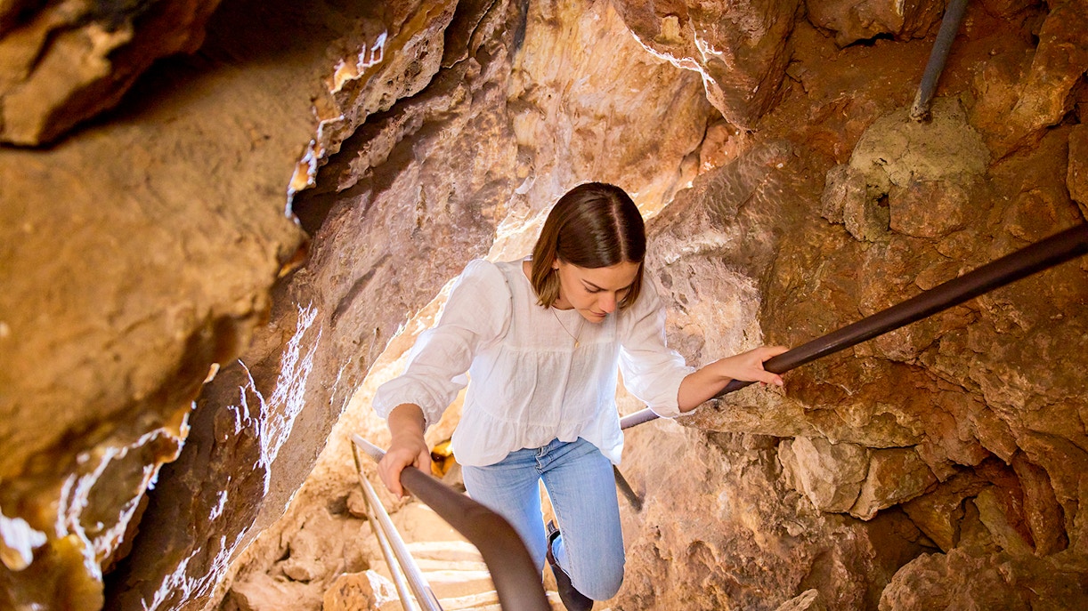 Tourist climbing up the stairs inside cave
