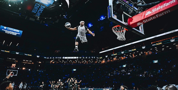 Basketball player performing a slam dunk at Barclays Center, home of the Brooklyn Nets.