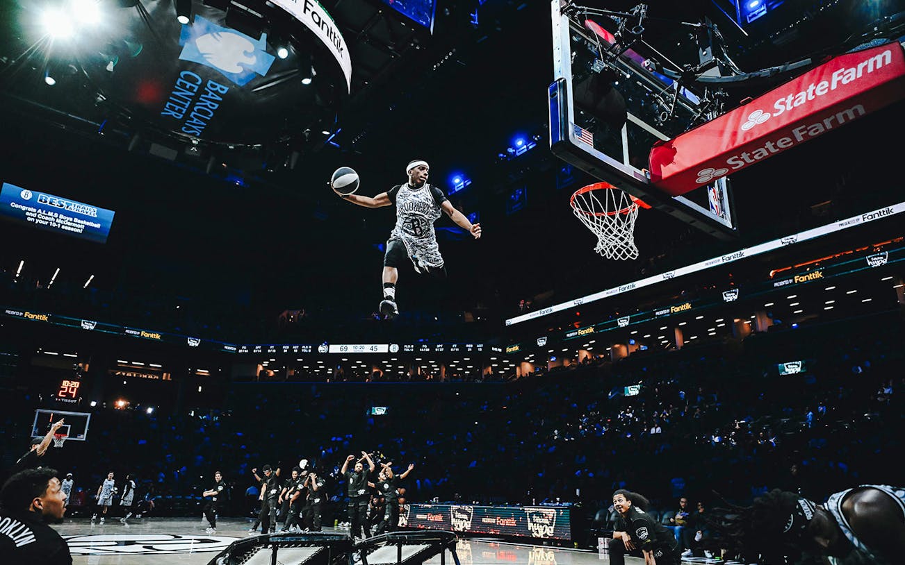 Basketball player performing a slam dunk at Barclays Center, home of the Brooklyn Nets.