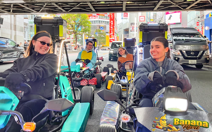 Go-kart riders on Banana Kart tour in Tokyo, driving through Shinjuku streets.