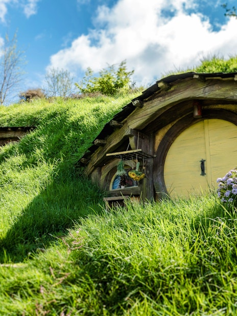 Hobbit house with round door and windows on Hobbiton movie set tour.