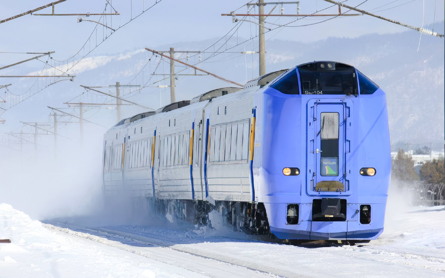 Train traveling on snowy JR Hokkaido Line in Japan.