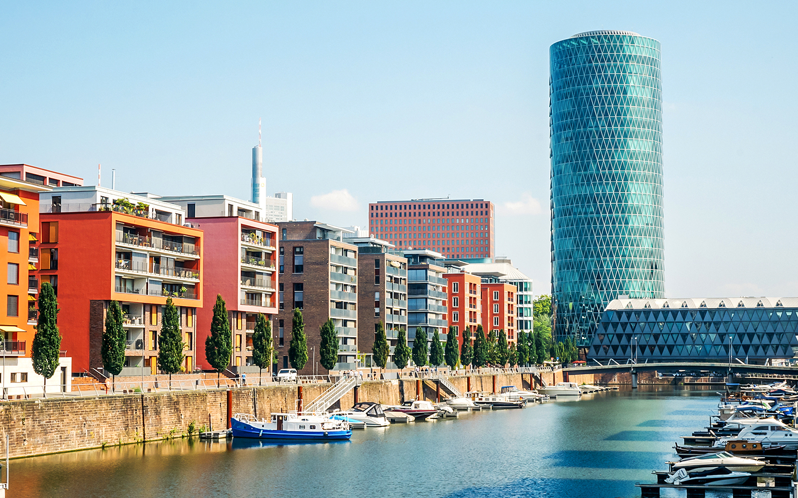 Westhafen Tower in Frankfurt with surrounding cityscape and river view.
