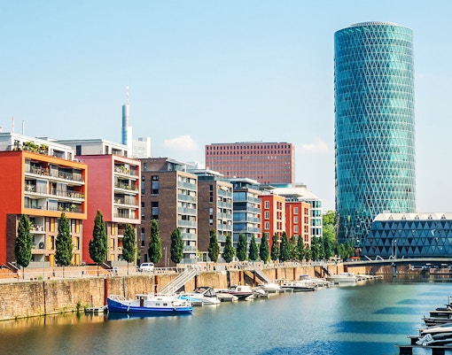 Westhafen Tower in Frankfurt with surrounding cityscape and river view.