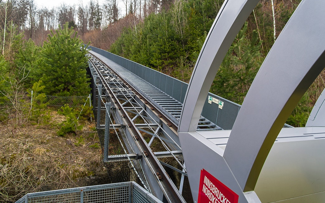 Nordkettenbahn funicular track through forested area in Innsbruck, Austria.