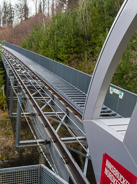 Nordkettenbahn funicular track through forested area in Innsbruck, Austria.
