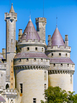 Château de Pierrefonds towers against a clear blue sky in France.