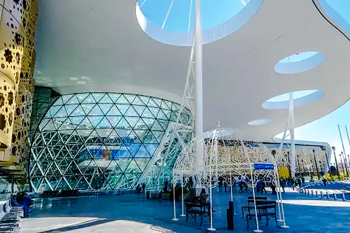 Marrakech Menara Airport exterior with modern architecture, glass facade, and travelers.