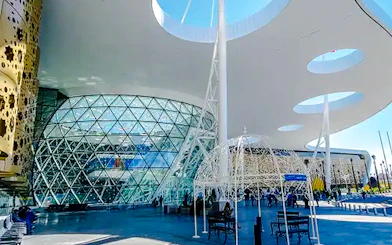Marrakech Menara Airport exterior with modern architecture, glass facade, and travelers.
