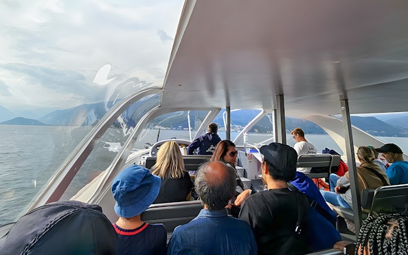 Passengers enjoying a scenic view on a boat trip in Lugano, Switzerland.