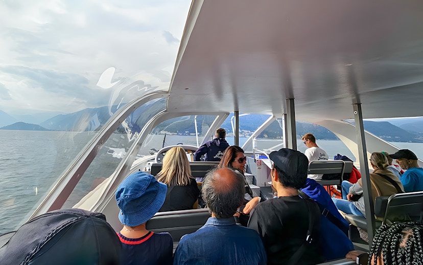 Passengers enjoying a scenic view on a boat trip in Lugano, Switzerland.