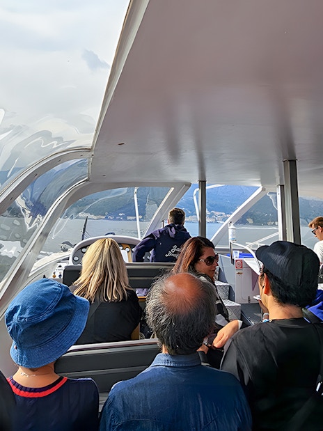 Passengers enjoying a scenic view on a boat trip in Lugano, Switzerland.