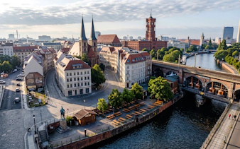 Berlin cityscape with historic buildings and a brewhouse along the river, part of Oktoberfest walking tour.