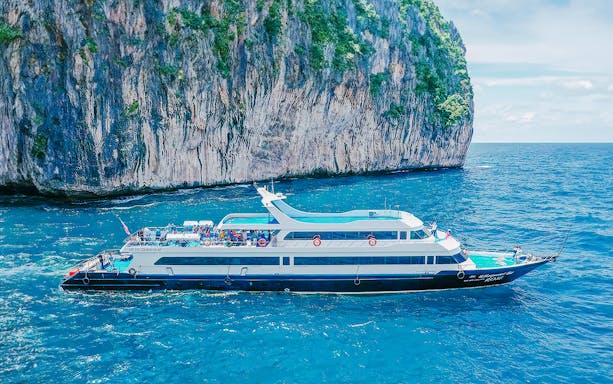 Ferry cruising near limestone cliffs in Phuket, en route to Phi Phi, Krabi, and Lanta.