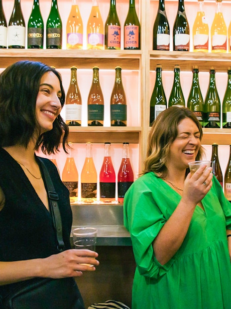 Visitors enjoying drinks at a wine stall in Borough Market, London.