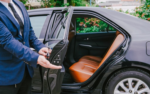 Luxury car interior with open door for transfer service.