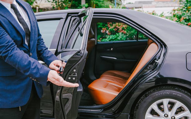 Luxury car interior with open door for transfer service.