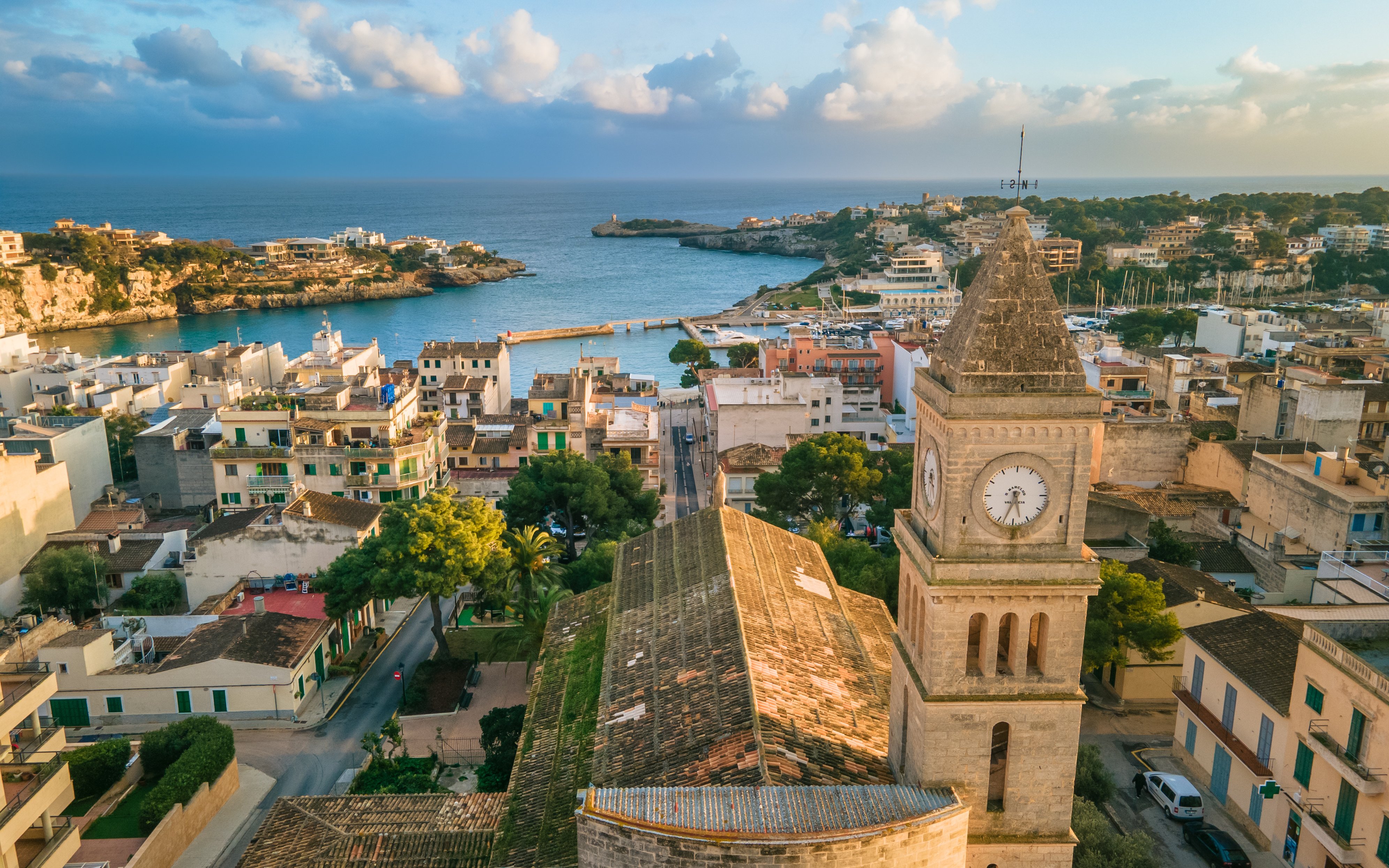 Panoramic view of Porto Cristo with a clock tower and harbor on Mallorca's east coast, Spain.