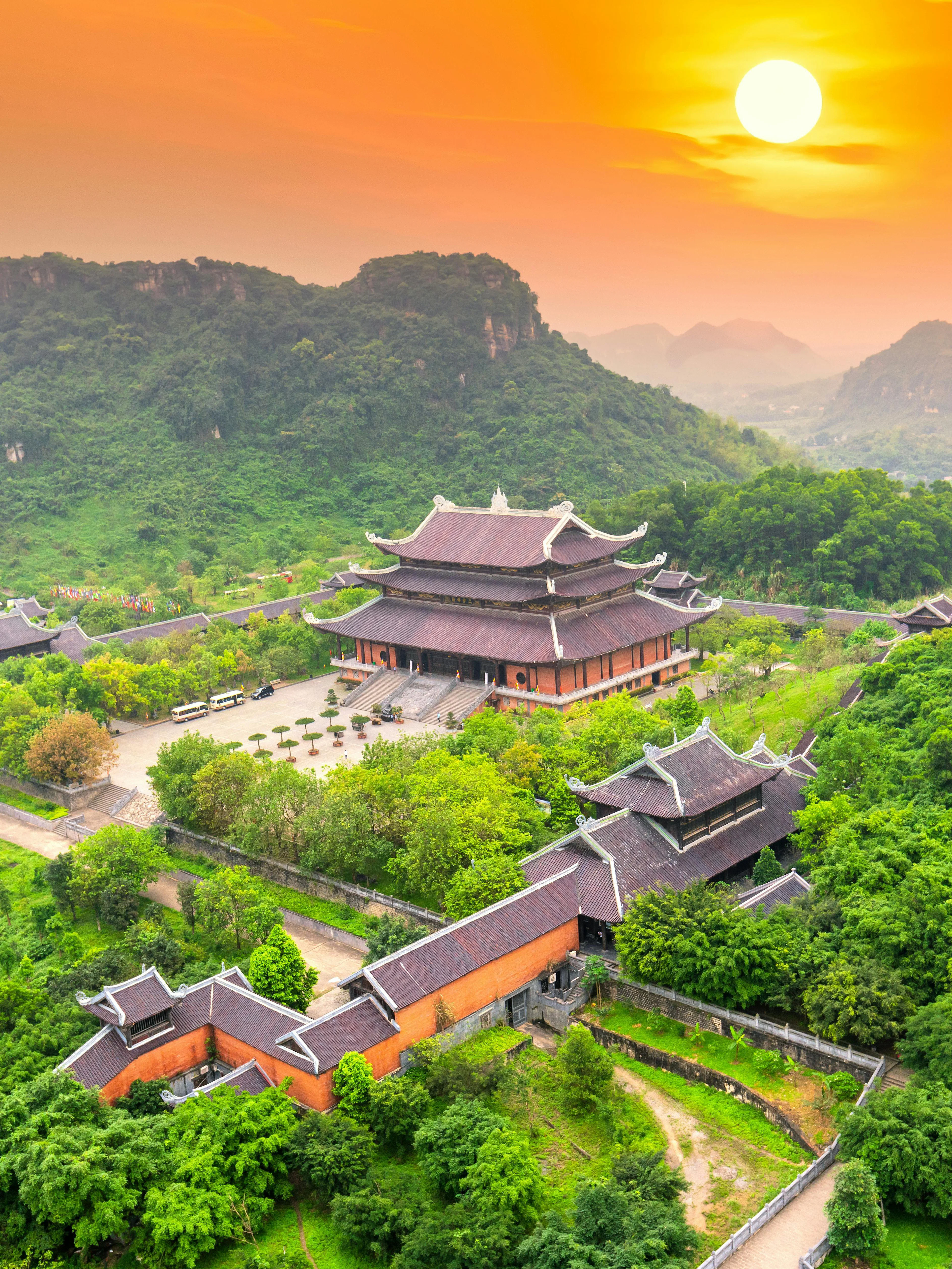 Bai Dinh temple complex at sunset, surrounded by lush greenery in Ninh Binh, Vietnam.
