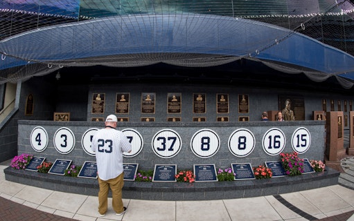 Yankee Stadium Monument Park with retired numbers and plaques, New York Yankees vs Detroit Tigers event.