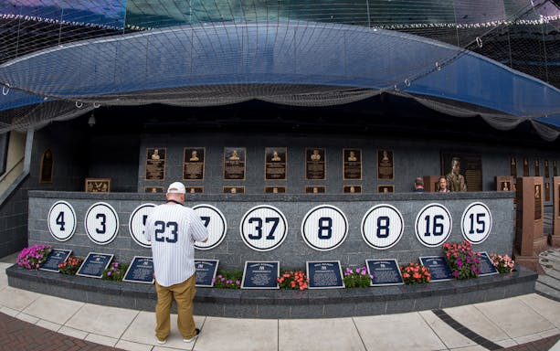 Yankee Stadium Monument Park with retired numbers and plaques, New York Yankees vs Detroit Tigers event.