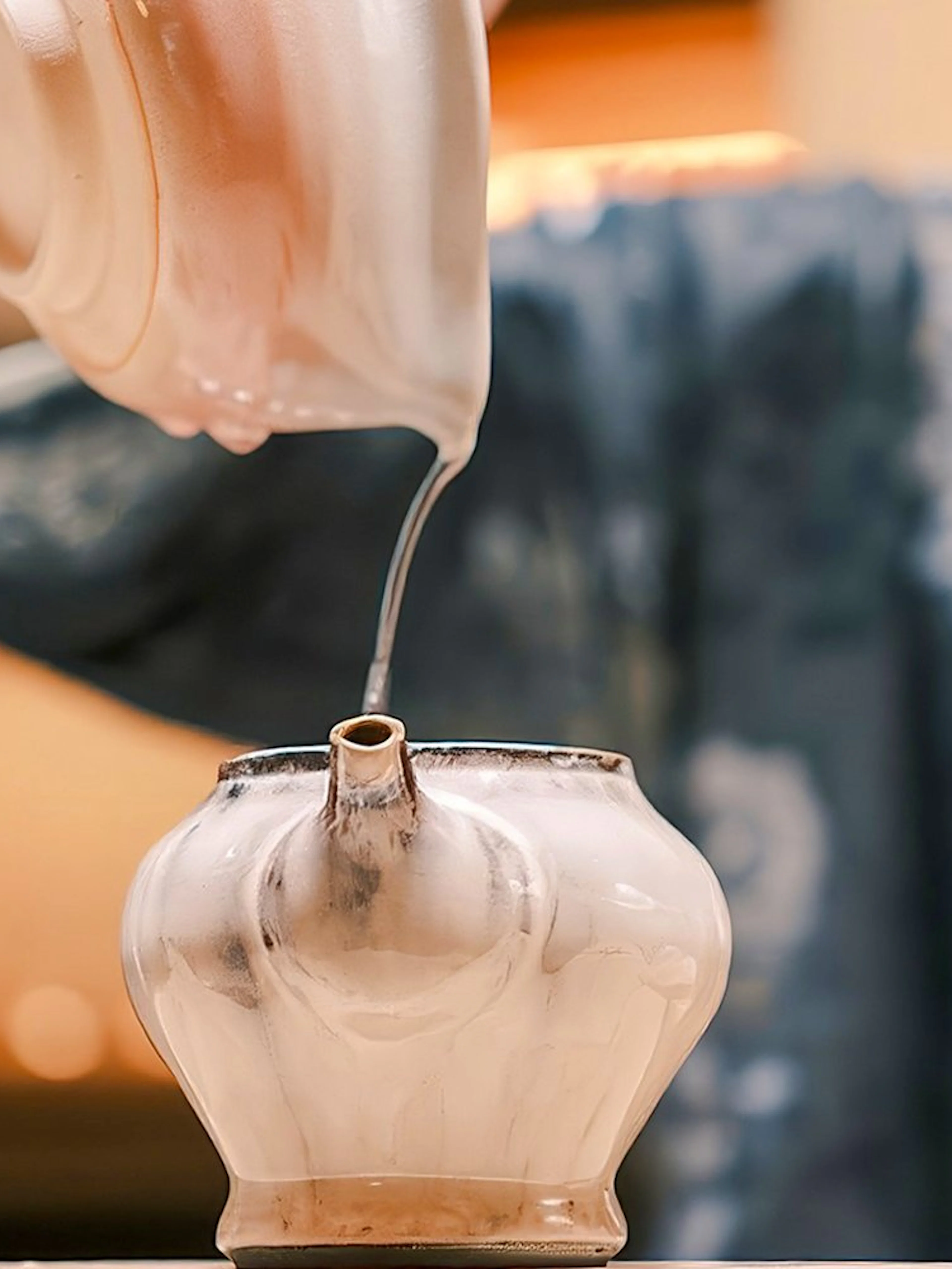 Pouring hot tea into a traditional pot during a private tea ceremony.
