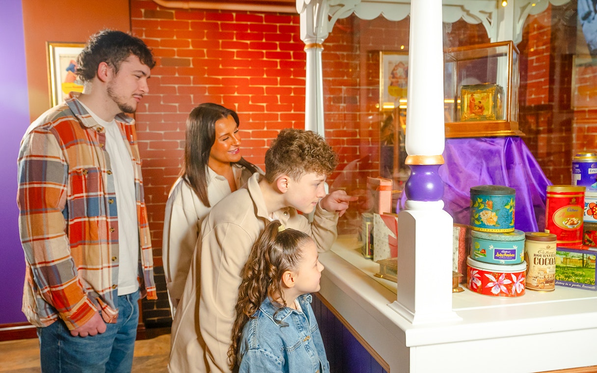 Guests viewing vintage chocolate tins at Bourneville Experience, Cadbury World.
