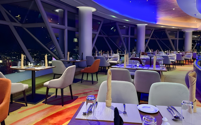 Dining area with city view at Orbit Revolving Restaurant, KL Tower, Kuala Lumpur, Malaysia.