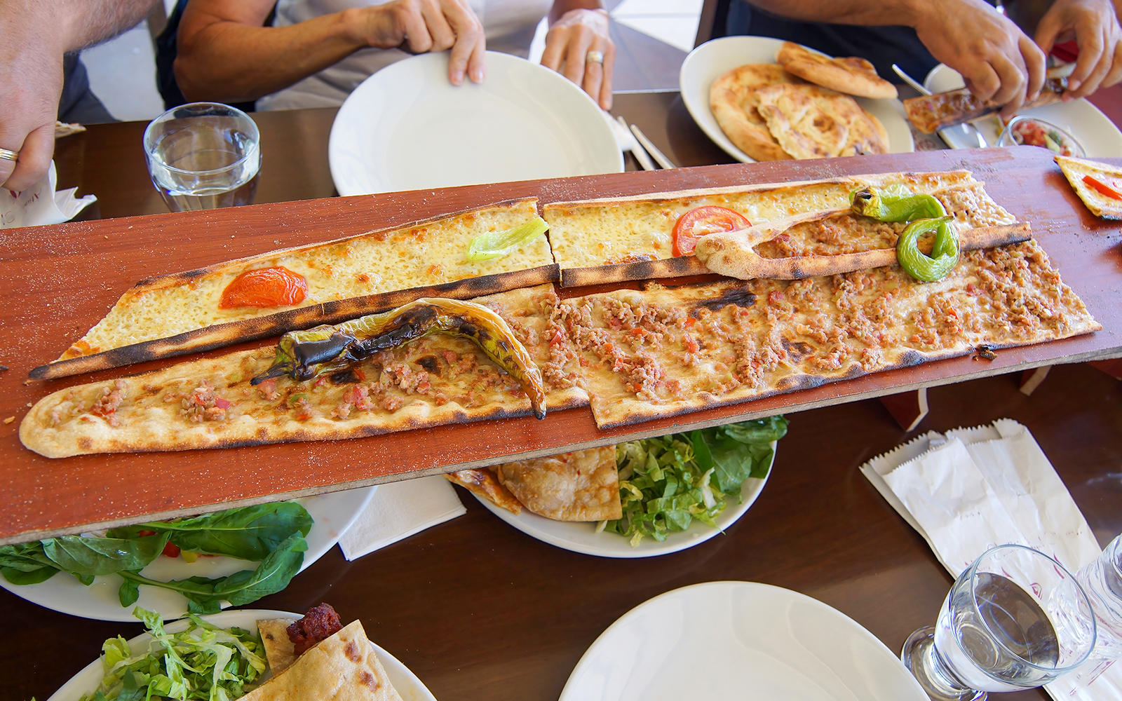 Turkish pide served on a wooden board during Antalya sightseeing city tour.