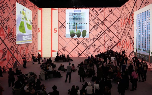 David Hockney exhibition with large digital art projections and seated audience.